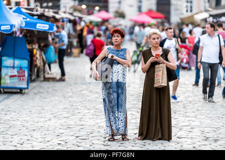 Lemberg, Ukraine - Juli 30, 2018: Zwei slawischen Osteuropa Ukrainische Frauen wandern in historischen Ukrainischen polnische Stadt in der Altstadt markt Rynok Square w Stockfoto