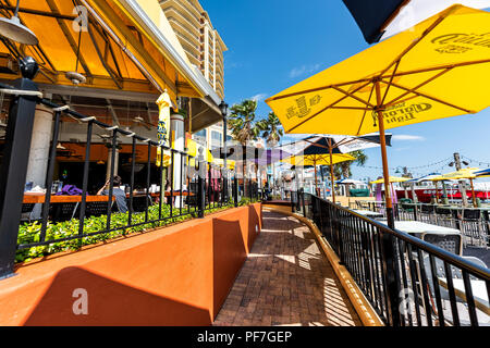 Destin, USA - 24. April 2018: Stadt Stadt village harborwalk Bürgersteig durch bunte gelb Cafe auf der Hafenpromenade während der sonnigen Tag in Florida panha Stockfoto