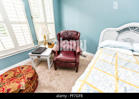 Neue, saubere Bett, Tisch, Lampe, vintage Strand Thema dekorative Blau Grün kissen im Schlafzimmer in der Inszenierung Modell Heim, Haus oder Wohnung durch rotes Leder couc Stockfoto