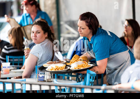 New Orleans, USA - 22. April 2018: Frau, weibliche Bedienung cajun kreolische Küche essen, Pommes, Suppe auf dem Markt Cafe Restaurant, Menschen sitzen Stockfoto