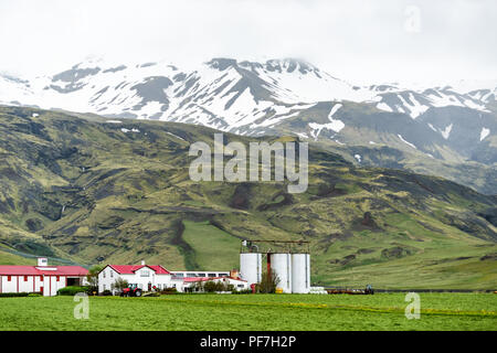 Schneebedeckt Schnee Berge Landschaft Blick auf Green Mountain Cliff an bewölkten Tag, südlich Ringstraße oder Golden Circle, Bauernhäuser in der Nähe von Vik Stockfoto