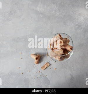 Wafer cremige Sticks in ein Glas Schale auf einem grauen Stein Hintergrund mit kopieren. Ansicht von oben. Stockfoto