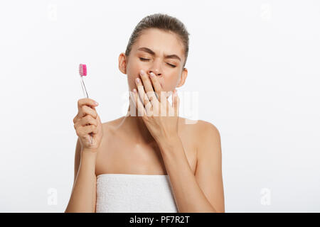 Schläfrige Frau, Frau, Bürsten, Zähne, Zahnbürste auf isolierten weißen Hintergrund. Stockfoto