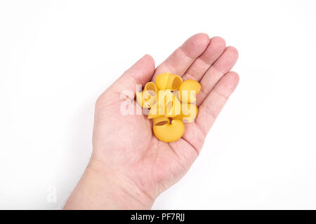 Pipe Rigate Pasta in einer Hand, auf weißem Hintergrund Stockfoto