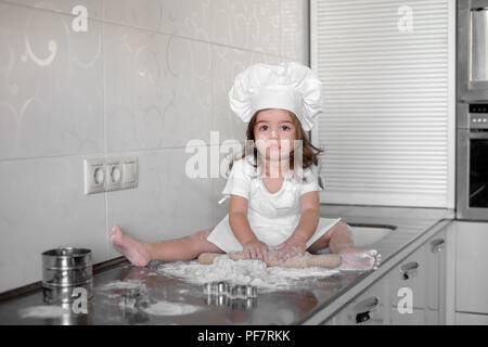 Kleines Mädchen, Teig und Plätzchen in der Küche Stockfoto