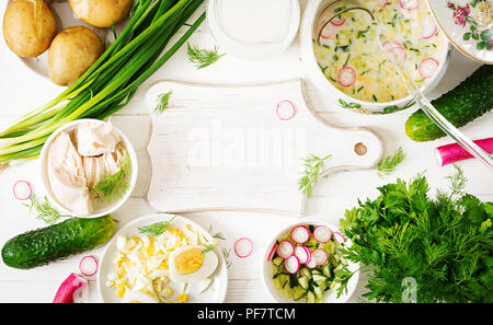 Zutaten zum Kochen Sommer Joghurt kalte Suppe mit Ei, Gurke, Huhn und Dill auf hölzernen Tisch. Okroshka. Russische Küche. Ansicht von oben. Flach. Mock Stockfoto