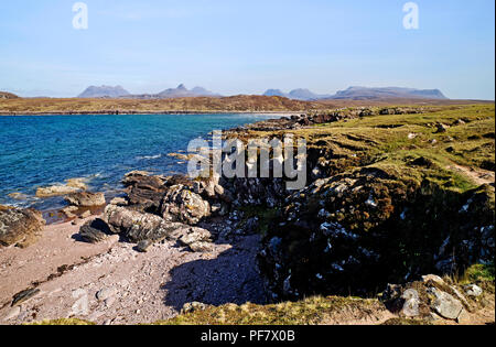 Blick über die felsige Küste von achnahaird Bay, Coigach, Scottish Highlands, zu Inverpolly Berge am Horizont. Stockfoto