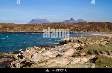 Blick über die felsige Küste von achnahaird Bay, Coigach, Scottish Highlands, zu Inverpolly Berge am Horizont. Stockfoto