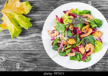 Frischer Salat von Garnelen, Muscheln und gemischte Salatblätter, Ansicht von oben Stockfoto