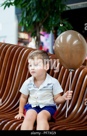 Little boy Holding braun Ballon. Stockfoto