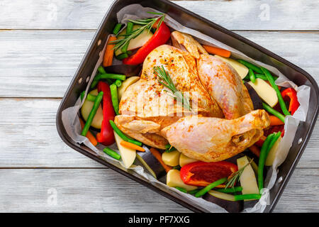 Raw ganzes Huhn mit bunten Stücke von Paprika, Kartoffeln. close-up Stockfoto