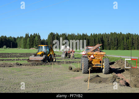 Traktoren und Bagger auf dem Feld, eine Drainage. Stockfoto