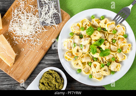 Tortellini mit grünen Erbsen, gebratene Pinienkerne, Ansicht von oben Stockfoto