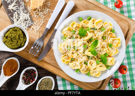 Tortellini mit grünen Erbsen, Pinienkerne, Parmesan und reibe Stockfoto