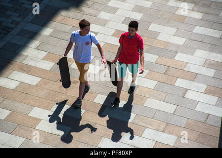 Russland, Moskau - 13. Mai 2018: Jugendliche mit skateboards und langen Schatten auf der Straße von Moskau Stockfoto