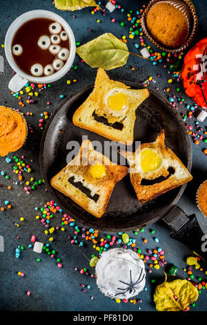 Ist lustig, Kinder behandelt für Halloween, eine Idee für ein festliches Frühstück. Sandwiches Toast mit Eiern, wie gruselig Monster, heiße Schokolade mit m Stockfoto