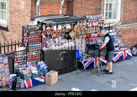 London, Großbritannien, 22. Juni 2018: Street Hersteller, Mann, männlich Verkäufer der Verkauf viele Souvenirs, Abzeichen, Postkarten, Magneten auf der Anzeige zu Touristen Stockfoto