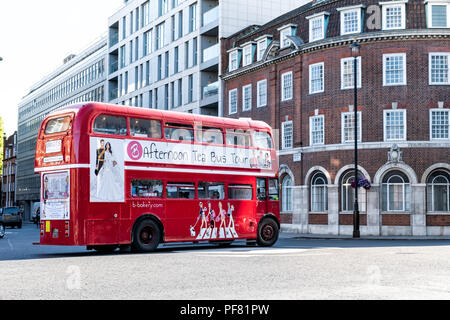 London, Großbritannien, 22. Juni 2018: Iconic, Classic Red Double Decker Bus fahren, Drehen am Schnittpunkt mit Menschen sitzen, essen während der Nachmittagstee Stockfoto