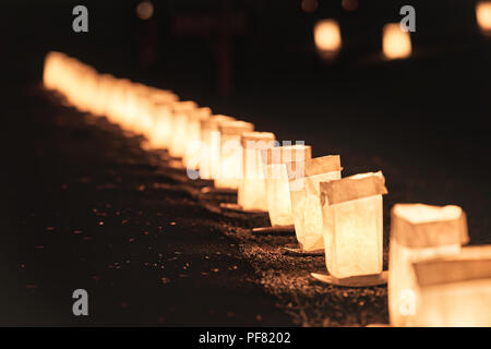 Zeile, Zeile von Heiligabend Kerzen, Laternen in Papiertüten in der Nacht entlang der Straße, Straße, Weg durch die Häuser im Wohngebiet beleuchtete ich Stockfoto