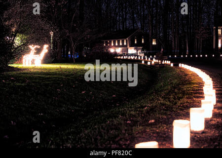 Zeile der Heiligabend urlaub Kerzen, Laternen in Papiertüten in der Nacht entlang der Straße, Straße, Weg durch die Häuser im Wohngebiet beleuchtet Stockfoto