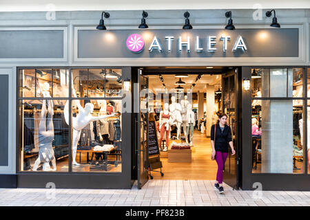 Tysons Corner, USA - 26. Januar 2018: athleta Store, Shop, Fassade, Storefront, Tür, Eingang mit Menschen, junge Frau zu Fuß in Einkaufszentrum in Vir Stockfoto