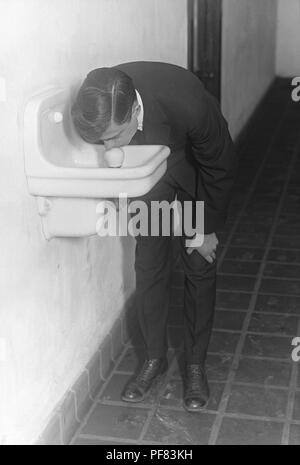 Mann trinken aus einem mangelhaft konzipiert Trinkwasserbrunnen auf dem Campus der Universität von Minnesota, 11. Mai 1917. Mit freundlicher Seuchenkontrollzentren (CDC)/Minnesota Abteilung der Gesundheit, R.N. Barr Bibliothek, Bibliothekare Melissa Rethlefsen und Marie Jones. () Stockfoto