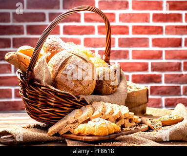 Noch immer leben Foto von Brot und Backwaren im Weidenkorb. Amerikanische und französische Toast zum Frühstück. Stockfoto