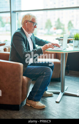 Senior Geschäftsmann mit Internet im Cafe Stockfoto