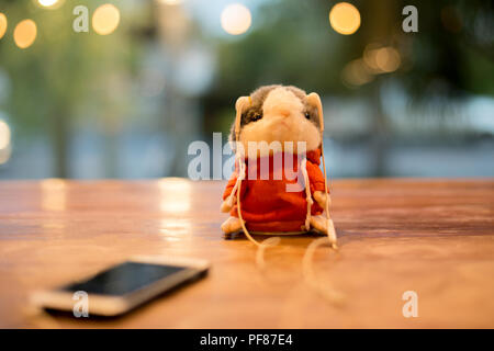 Kleine hamster Maus Puppen mit Kopfhörer auf hölzernen Tisch in Bokeh hellen Hintergrund Stockfoto