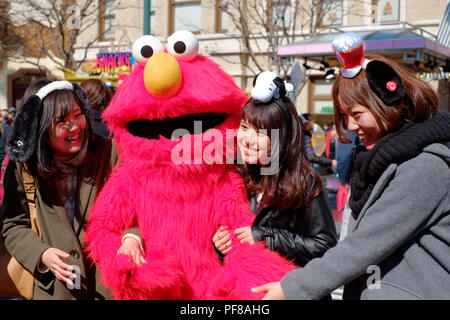 Gerne asiatische Mädchen nehmen Schuss mit Sesam-Straße Elmo in Universal Studios Japan (USJ), Osaka, Japan Stockfoto