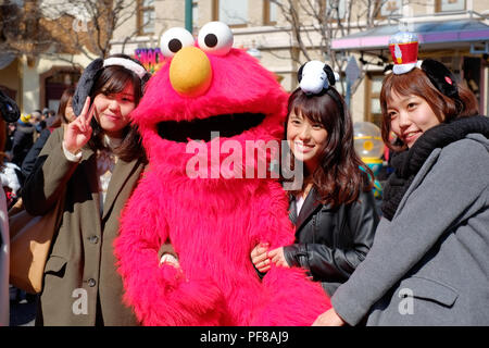 Gerne asiatische Mädchen nehmen Schuss mit Sesam-Straße Elmo in Universal Studios Japan (USJ), Osaka, Japan Stockfoto