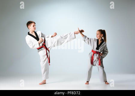 Die Studioaufnahme Gruppe von Kinder Ausbildung Karate Martial Arts auf graue backlground Stockfoto