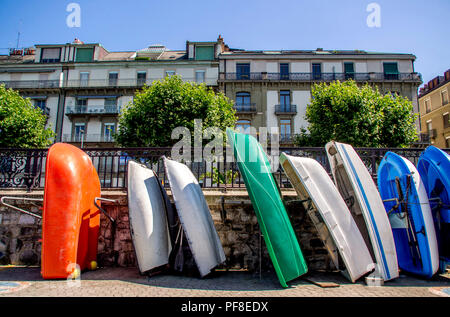 Ausrichtung von multicolores kleine Boote entlang einer Wand vor den Gebäuden in Genf. Die Schweiz. Europa Stockfoto