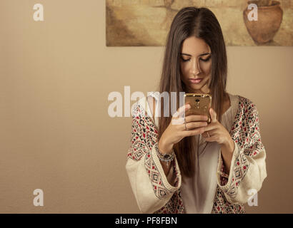 Hübsches Mädchen stehen auf Ihrem Mobiltelefon konzentriert. Stockfoto