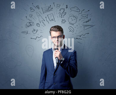 Geschäftsmann sprechen in das Mikrofon mit gemischten Doodles über seinem Kopf Stockfoto