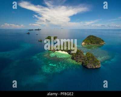 Eine Drohne Foto von atemberaubenden, kleine, tropische Inseln, Meer & Coral Reef in Raja Ampat Marine Park, West Papua, Indonesien Stockfoto