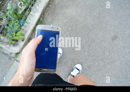 19. August 2018 - Bukarest, Rumänien. Ein Mädchen in converse Surfen im Facebook App. Stockfoto
