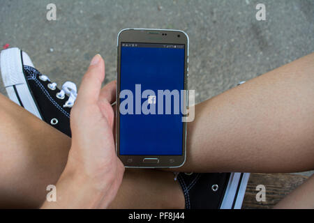 19. August 2018 - Bukarest, Rumänien. Ein Mädchen in converse Surfen im Facebook App. Stockfoto