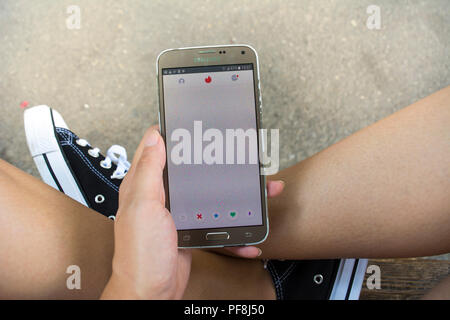 19. August 2018 - Bukarest, Rumänien. Ein Mädchen surfen im Zunder Anwendung und zu warten, bis es zu laden. Stockfoto