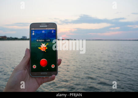 19. August 2018 - Bukarest, Rumänien. Erfassung einer Person spielen Pokemon gehen auf seinem Samsung Handys und den Sonnenuntergang bei der Landschaft Stockfoto