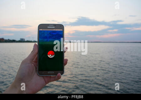 19. August 2018 - Bukarest, Rumänien. Erfassung einer Person spielen Pokemon gehen auf seinem Samsung Handys und den Sonnenuntergang bei der Landschaft Stockfoto