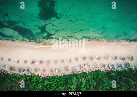 Antenne drone Blick auf einen wunderschönen Strand mit weißem Sand und Sonnenschirme. Stockfoto