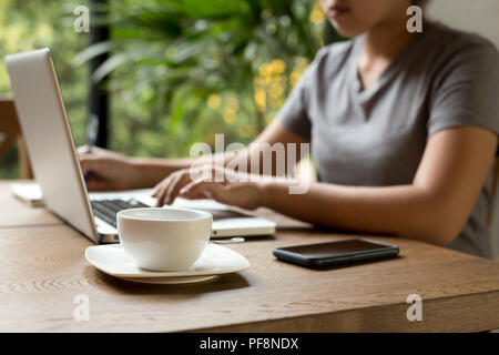 Ausgewählte Schwerpunkte Tasse Kaffee auf dem Tisch mit junge Frau stude Stockfoto