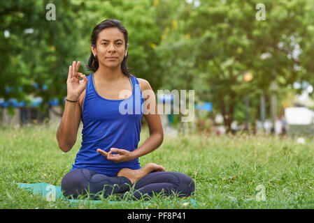 Yoga im Park Thema. Junge Frau Yoga im Green Park Hintergrund Stockfoto