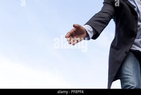 Hilfe Konzept Hand erreichen, jemanden mit blauem Himmel helfen Stockfoto