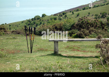 Leere Holzbank mit vier Stöcke auf der South West Coastal Path, Somerset, England, UK. Stockfoto