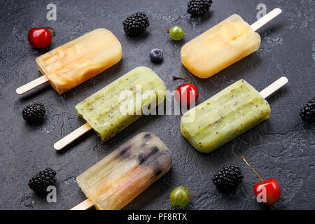 Foto gefrorener Fruchtsaft auf Stöcke und Beeren Stockfoto
