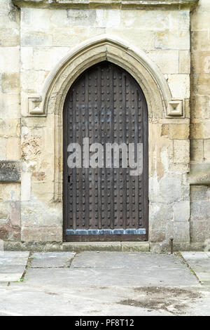 Die verzierte Kirche Tür in alten Steinmauer gesetzt Stockfoto