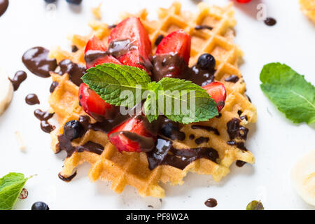 Waffeln mit frischen Erdbeeren und Schokolade Topping. Süße Nachspeise auf weißem Hintergrund. Close Up. Stockfoto