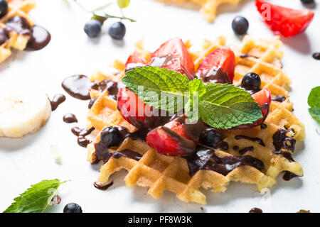 Waffeln mit frischen Erdbeeren und Schokolade Topping. Süße Nachspeise auf weißem Hintergrund. Close Up. Stockfoto